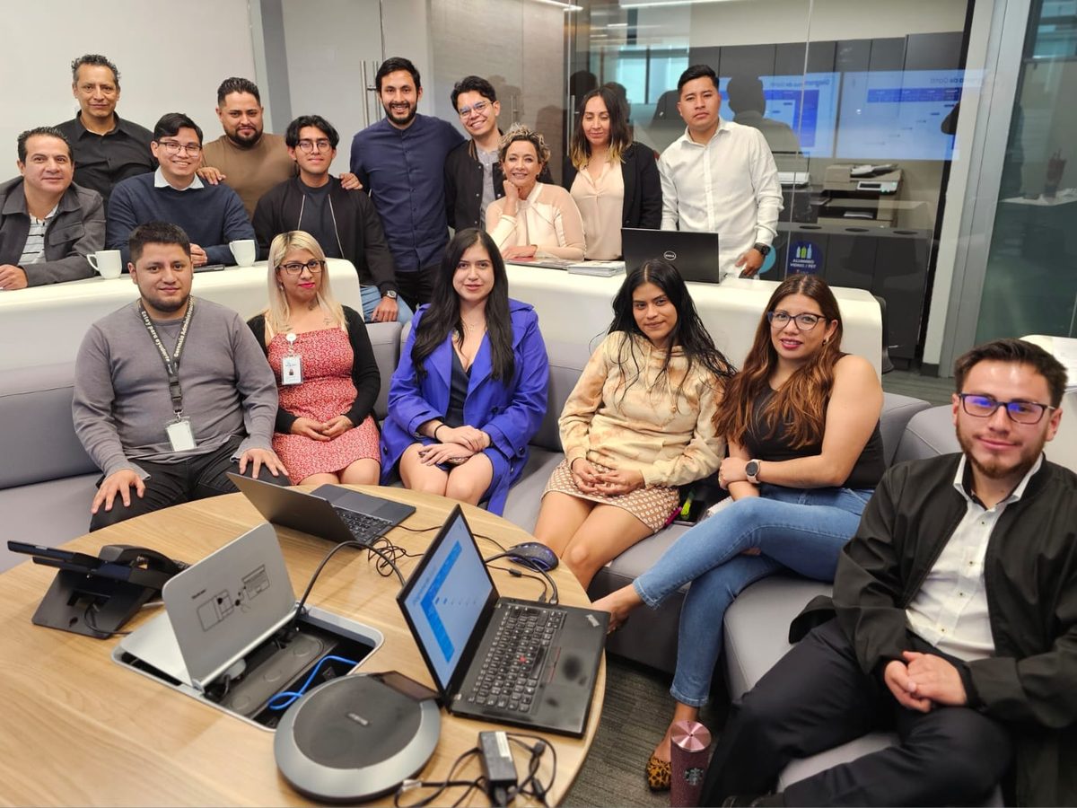 El equipo de Pernexium reunido alrededor de una mesa con laptops en su oficina.